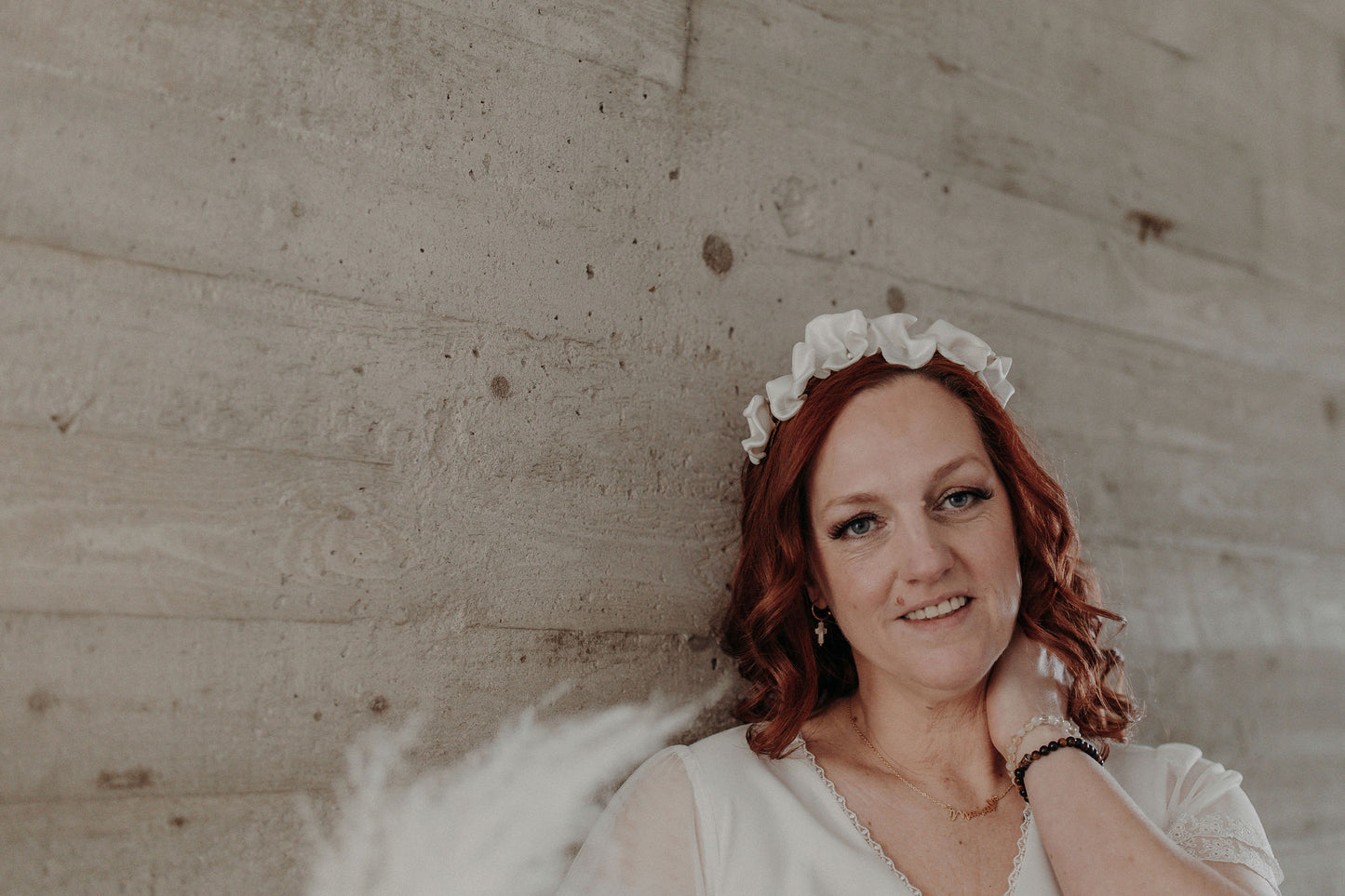 Couronne Celeste en fleurs blanches en porcelaine sur cheveux bouclés
