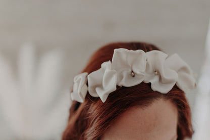 Couronne Celeste en fleurs blanches en porcelaine sur cheveux bouclés
