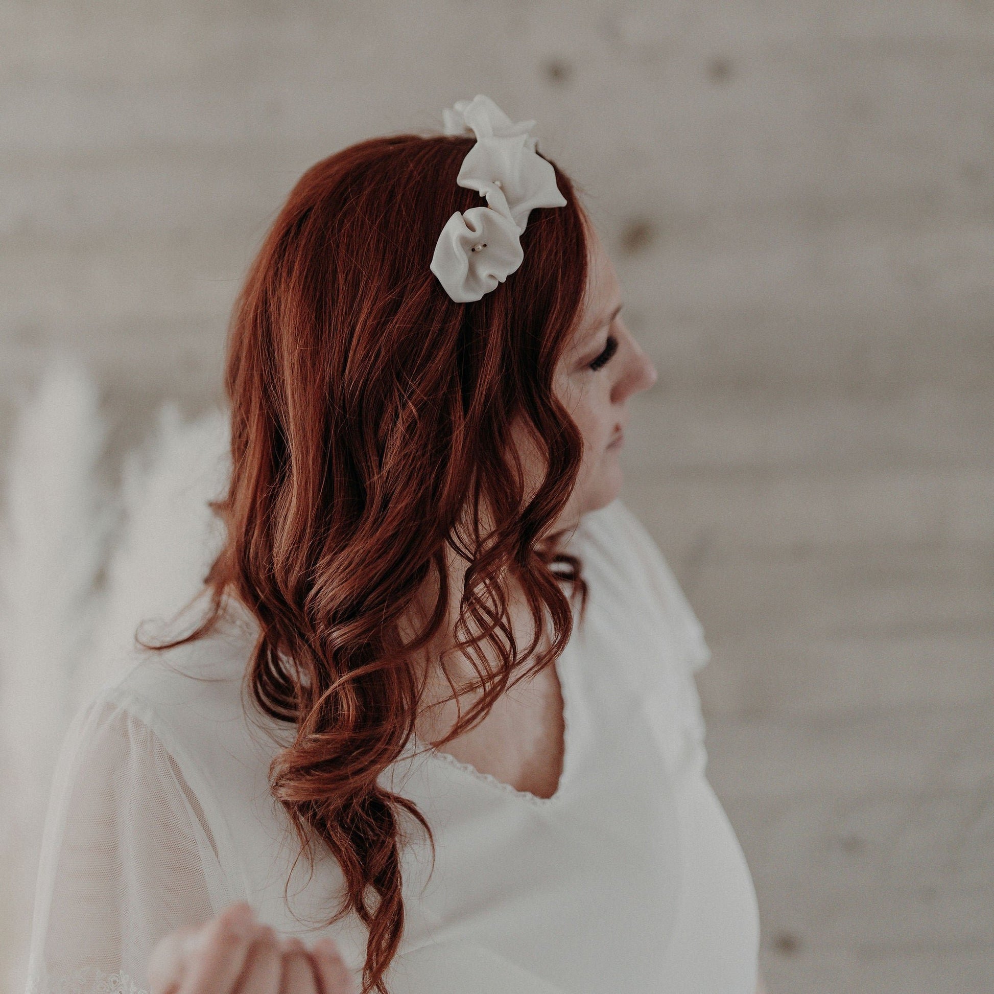 Couronne Celeste en fleurs blanches en porcelaine sur cheveux bouclés