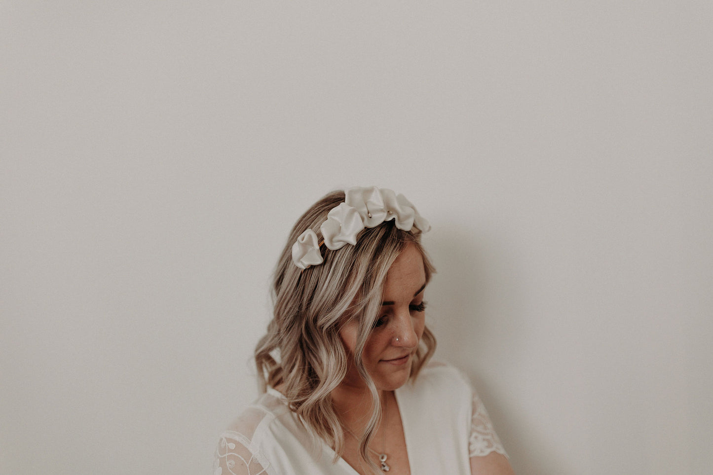 Couronne Celeste en fleurs blanches en porcelaine sur cheveux au carré bouclés