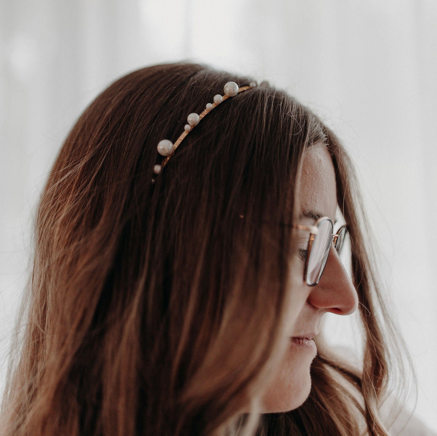 Couronne Elise en perles nacrée dans des cheveux bruns lachés bouclés