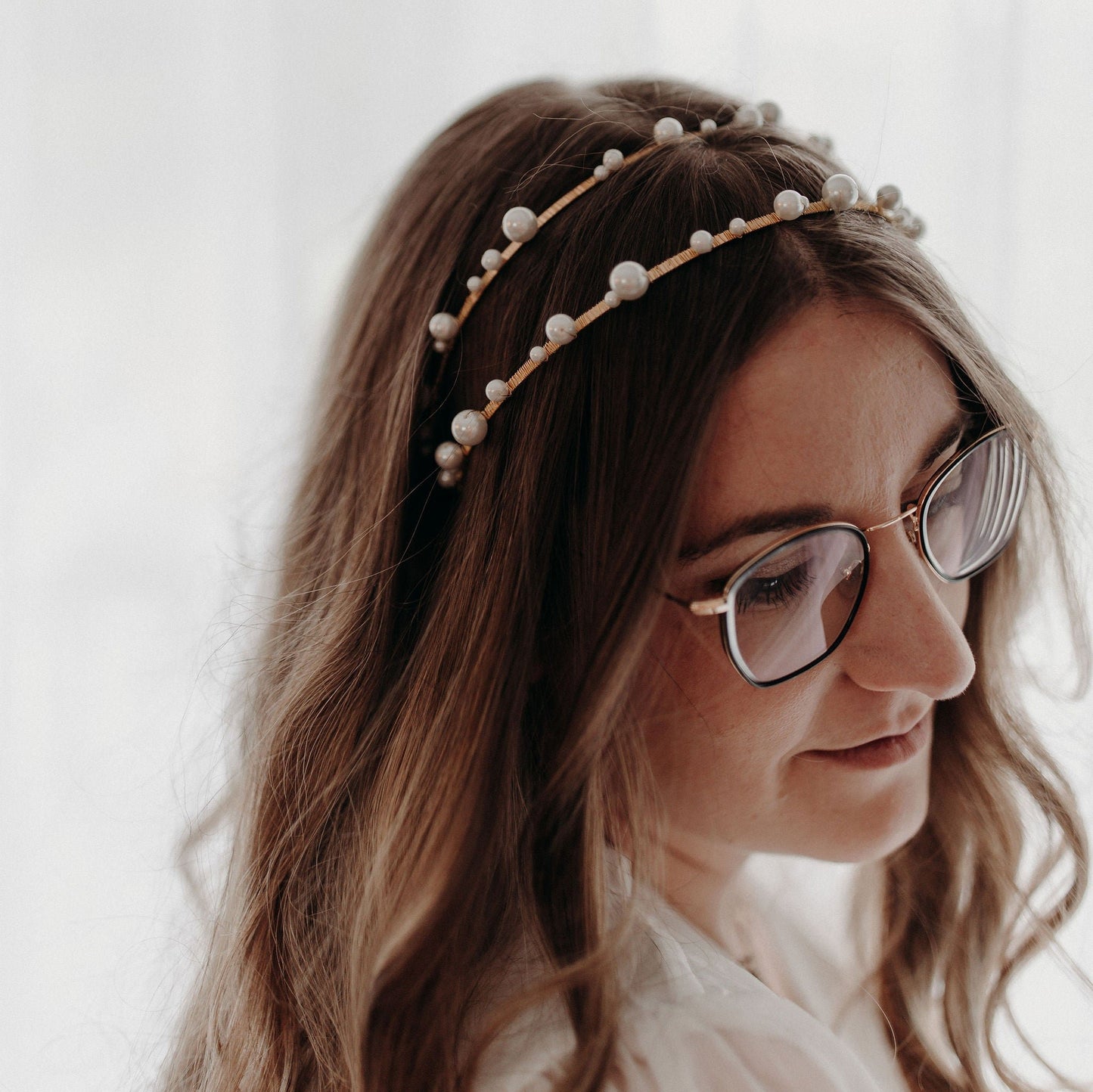 Couronne Elise en perles nacrée dans des cheveux bruns bouclés